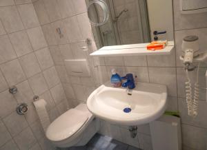 ein Badezimmer mit Waschbecken, Toilette und Spiegel in der Unterkunft Zentrales Apartment für 2 *Bogenstraße* in Norderney
