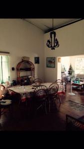 a dining room with a table and chairs and a chandelier at Coqueiros Praia Martin de Sá in Caraguatatuba