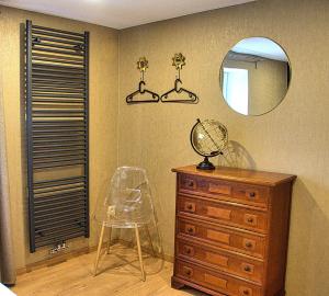 a room with a dresser and a mirror and a chair at Côté Champlon in Tenneville