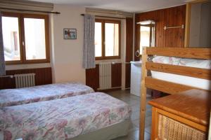 1 Schlafzimmer mit 2 Betten, einem Waschbecken und 2 Fenstern in der Unterkunft LE GÎTE LES MELEZES in Villar-dʼArène