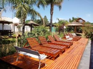 a row of wooden benches sitting on a wooden deck at Hotel Bialet Massé in Bialet Massé