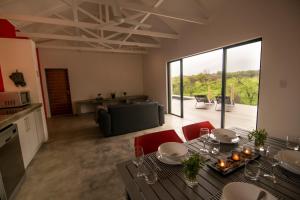 a living room with a dining table and a kitchen at Kruger Cliffs Lodge in Hoedspruit