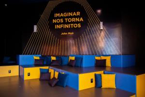 a blue and yellow bench with pillows in front of a sign at ibis budget Tambore in Barueri
