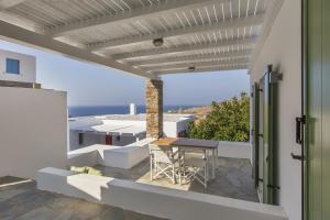 un patio con mesa y vistas al océano en Minimal Apartment with a swimming pool and sea view in Koundouros en Koundouros