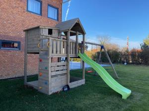 a wooden playground with a slide in a yard at Rómahegy Rendezvényház in Kaposvár