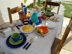 a white table with plates of food on it at Villa Arte Pousada Morro Branco in Beberibe