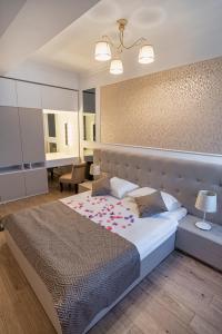 una camera da letto con un letto grande e una scrivania di Solid Residence Apartments a Mamaia