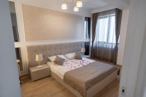 a bedroom with a bed and a window at Oasis by the Lake - Solid Residence Mamaia Apartment in Mamaia