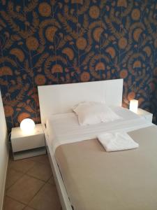 ヴィルヌーヴ・レ・ザヴィニョンにあるChambre avec tout le confort d'un appartementの黒とオレンジの壁紙を使用したベッド1台が備わるベッドルーム1室