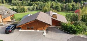a house with a car parked in front of it at Bienvenue dans notre chalet! Appartement Les Sitelles in Le Grand-Bornand