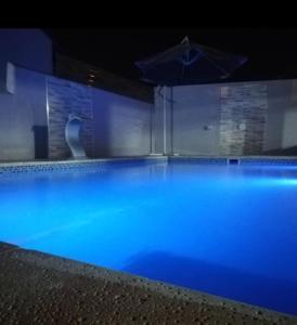 a large swimming pool with an umbrella in the dark at Apart portal de la selva in Puerto Iguazú