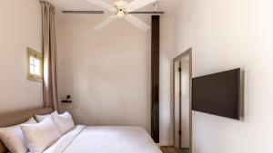 um quarto com uma cama e uma ventoinha de tecto em Ruby em Tel Aviv