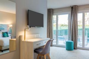 - une chambre avec un bureau, une télévision et un lit dans l'établissement Best Western Plus Hyères Côte D'Azur, à Hyères 82 autres photos