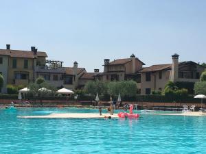 a pool with an island in the middle of the water at Garda Resort Village in Peschiera del Garda