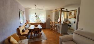 a living room with a table and a kitchen at Casa Mia in Vadena