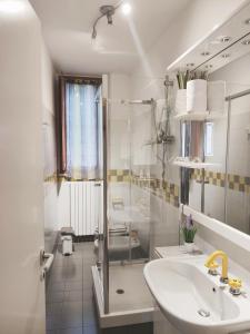 een witte badkamer met een wastafel en een douche bij Aduepassi in Ascoli Piceno