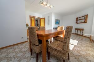 a dining room with a wooden table and chairs at HomeHolidaysRentals Bonte in Malgrat de Mar
