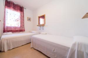 a white room with two beds and a window at HomeHolidaysRentals Bonte in Malgrat de Mar