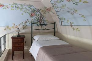 a bedroom with a bed with a tree mural on the wall at B&B La Riviera in Gallipoli