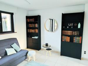 salon z kanapą i lustrem w obiekcie Maison familiale tout confort avec garage w mieście Lompret