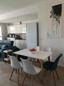 Piso Sevilla في Gelves: غرفة معيشة مع طاولة وكراسي بيضاء