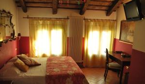 sypialnia z łóżkiem, biurkiem i zasłonami w obiekcie Relais Alcova del Doge w mieście Mira