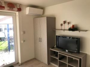 uma sala de estar com uma televisão e um armário em Pervalka 13-5 em Pervalka