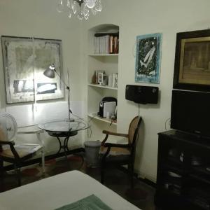 uma sala de estar com uma mesa e cadeiras e uma televisão em Studiocasarte em Ovada