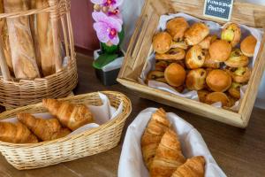 a table topped with baskets of bread and pastries at Best Western Plus Hyères Côte D'Azur in Hyères