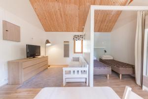 sala de estar con cama y TV en Yyteri Holiday Cottages, en Pori