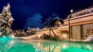 Un resort con un albero di Natale nella neve di Dolasilla Mountain Panoramic Wellness Hotel a La Villa