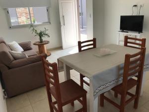 Alquiler Temporario Los Olivos في جونين: غرفة معيشة مع طاولة وكراسي وأريكة