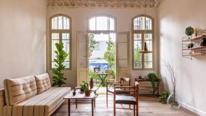 un soggiorno con divano, tavoli e finestre di Ruby a Tel Aviv