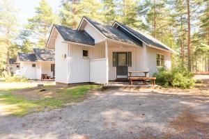 a white house with a bench in front of it at Yyteri Holiday Cottages in Pori