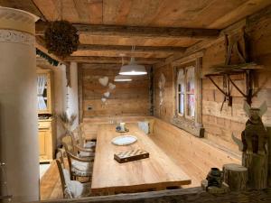 ein Esszimmer mit einem Holztisch in einer Hütte in der Unterkunft Villa la Dama del Lago in Molveno