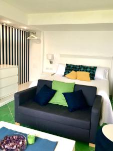 ein Schlafzimmer mit einem Bett und einem Sofa mit Kissen in der Unterkunft Sorrento Garden in Sorrent