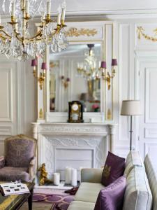 a living room filled with furniture and a fireplace at Hôtel Plaza Athénée - Dorchester Collection in Paris