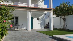 Casa blanca con patio con mesa en Casa Velero 32, en Sanlúcar de Barrameda