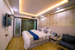1 dormitorio con 1 cama, TV y sofá en 一方砚·旅拍体验民宿, en Fenghuang