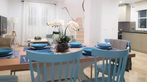 サンルーカル・デ・バラメダにあるCasa Velero 32のダイニングルーム(テーブル、青い椅子付)