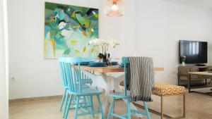 comedor con mesa y 2 sillas azules en Casa Velero 32, en Sanlúcar de Barrameda