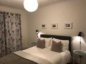 1 dormitorio con 1 cama con sábanas y almohadas blancas en CROFT 14 SWORDALE, en Swordale