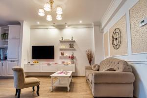 a living room with a couch and a tv at Oasis by the Lake - Solid Residence Mamaia Apartment in Mamaia