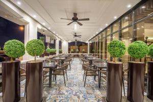 a dining room with tables and chairs and plants at Ewaa Express Hotel - Gaber in Riyadh