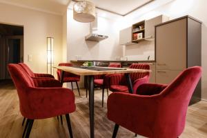 Bliesransbacher 8 في ساربروكن: غرفة طعام مع كراسي حمراء وطاولة وطبور