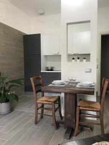 a kitchen with a wooden table with chairs and a counter at ValpoHome&Rooms in Negrar