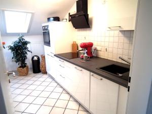 a kitchen with white cabinets and black counter tops at Ferienwohnung Das Inge die Oberne in Bernau in Bernau am Chiemsee