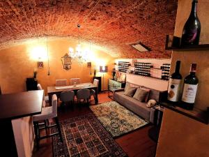 佛羅倫斯的住宿－La Cave Rouge - Secret wine cellar in the center，客厅配有沙发和带葡萄酒瓶的桌子