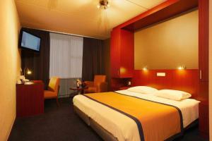 a hotel room with a bed and a television at Hotel Parkzicht in Veendam