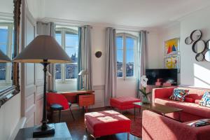 uma sala de estar com mobiliário vermelho e janelas em La Residence Du Vieux Port em Marselha